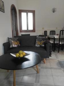 una sala de estar con sofá y un bol de fruta en una mesa en La Vila, en Villajoyosa
