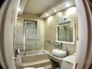 a bathroom with a tub and a sink and a toilet at Apartmani "Mimoza" in Otočac +58 photos