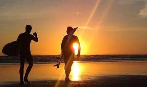 two men walking on the beach at sunset at King's Head Inn in Llangennith