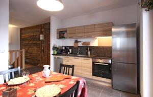 een keuken met een tafel en een koelkast bij Odalys Chalet De Louis in L'Alpe-d'Huez