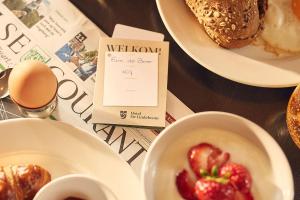 a table with plates of food and a bowl of strawberries at Het Polderhuis in Den Burg