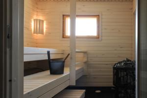 a sauna with a tub in a wooden cabin at Hidden House Pirttijärvi in Jämsä