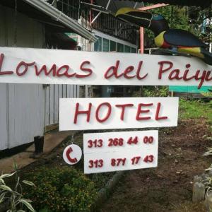 um sinal para um hotel em frente a uma casa em Hotel Lomas del Paiyü em Puerto Nariño