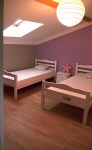 2 Betten in einem Zimmer mit einer Decke in der Unterkunft La Thébaïde in Saint-Amour