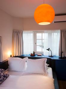 a bedroom with a bed with white pillows and a window at SWEETS - Beltbrug in Amsterdam