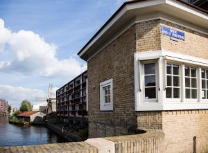 un edificio in mattoni con finestra accanto a un fiume di SWEETS - Beltbrug ad Amsterdam