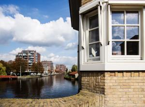 a window on the side of a building next to a river at SWEETS - Beltbrug in Amsterdam