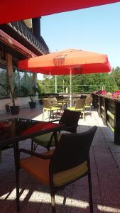 a patio with tables and chairs and an umbrella at Hotel Bitov in Bítov