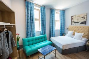 a bedroom with a bed and a blue couch at Casa de la Merced Suites in Málaga