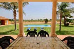 a table and chairs on a porch with a swimming pool at Finca las Ranas by CARLOSFERIEN in Denia +40 photos