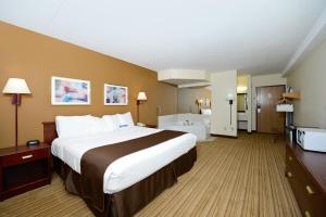 a hotel room with a large bed and a bathroom at Americas Best Value Inn Decatur in Decatur