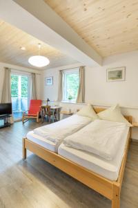 a bedroom with a large bed and a living room at Hotel Hohe Flum in Schopfheim