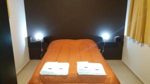an orange bed in a room with two lamps at Posada Entre Dos in Mina Clavero +24 photos