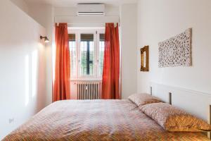 a bedroom with a bed with orange curtains and a window at New Capolinea 5 - Apartment in Milan