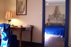a bedroom with a bed and a desk with a lamp at Domaine du Peyron in Quintenas