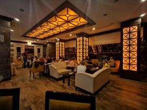 a lobby of a restaurant with people sitting at White Park Hotel in Sarıkamıs