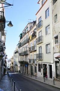 uma rua vazia em frente a um edifício branco alto em Santana 3 - Checkinhome em Lisboa