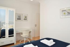 um quarto com uma cama, uma secretária e uma cadeira em Santana 3 - Checkinhome em Lisboa