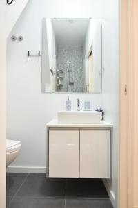 een witte badkamer met een wastafel en een spiegel bij Santana 3 - Checkinhome in Lissabon