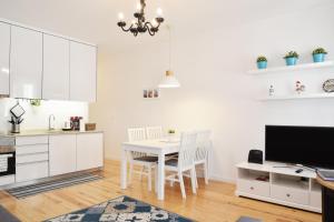 uma cozinha com armários brancos e uma mesa com cadeiras em Santana 3 - Checkinhome em Lisboa