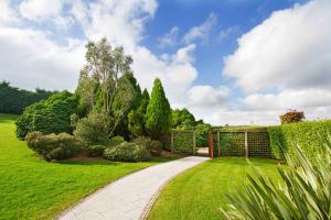 een tuin met een poort en een groen gazon bij La Mon Hotel & Country Club in Castlereagh