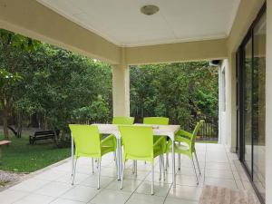 een veranda met een tafel en stoelen op een patio bij Sand River Cottages in Hazyview