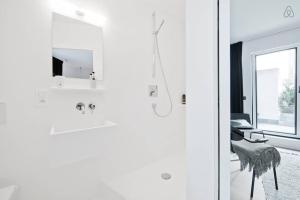 bagno bianco con doccia e specchio di B&B Lucy in the Sky ad Anversa Altre 12 foto