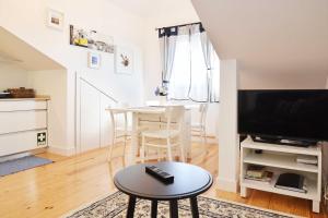 a living room with a table and a tv at Santana 4 - Checkinhome in Lisbon