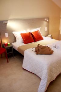 um quarto de hotel com duas camas com almofadas laranja em VVF Collonges-la-Rouge em Collonges-la-Rouge