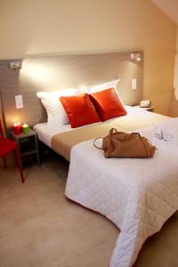 a hotel room with two beds with orange pillows at VVF Collonges-la-Rouge in Collonges la rouge