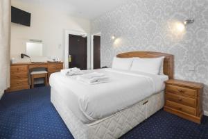 a bedroom with a large white bed and a desk at Lobster Hall - Room Only in Whitby