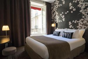 a hotel room with a bed and a window at Hotel Voltaire Opera Nantes Centre in Nantes