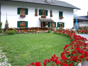 una casa con fiori rossi davanti di Casa Cristina 1 a Molveno