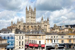 um grande edifício com uma torre de relógio em cima em Stunning Spacious Central Apartment near Parade Gardens em Bath