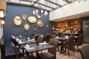a restaurant with tables and chairs and mirrors on the wall at Hotel Voltaire Opera Nantes Centre in Nantes