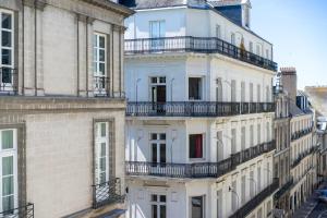 a group of white buildings with balconies on them at Hotel Voltaire Opera Nantes Centre in Nantes