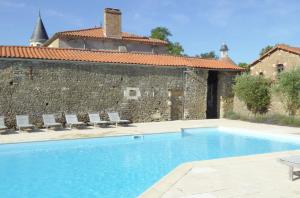 uma piscina em frente a um edifício com cadeiras em Chateau Breduriere em Moutiers-sur-le-Lay