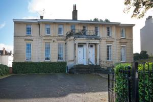 an old house with a gate in front of it at Wolcote House in Cheltenham