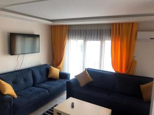 ein Wohnzimmer mit einem blauen Sofa und einem Fernseher in der Unterkunft Luxx Suite Mecidiyeköy in Istanbul