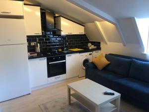 ein Wohnzimmer mit einer blauen Couch und einer Küche in der Unterkunft Luxx Suite Mecidiyeköy in Istanbul