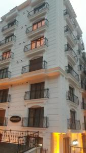 ein hohes weißes Gebäude mit Fenstern und Balkonen in der Unterkunft Luxx Suite Mecidiyeköy in Istanbul