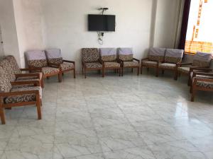 a waiting room with chairs and a tv on a wall at Hotel Hari darshan in Nāthdwāra