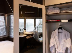a dressing room with a robe and a bed and a desk at SWEETS - Wiegbrug in Amsterdam