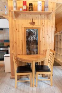 a wooden table and chairs in a kitchen at Pine Marten Bar Glenmore Treehouse in Aviemore