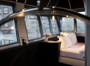 a bedroom with a bed in a room with windows at SWEETS - Wiegbrug in Amsterdam