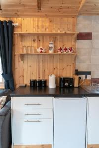 a kitchen with white cabinets and a counter top at Pine Marten Bar Glenmore Treehouse in Aviemore