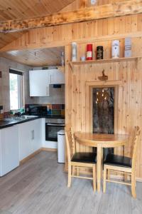 een keuken en eetkamer met een tafel en stoelen bij Pine Marten Bar Glenmore Treehouse in Aviemore