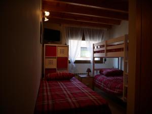 a bedroom with two bunk beds and a window at Sol Tarter - Vacances Pirinenca in El Tarter