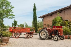 un trattore rosso che traina una carrozza trainata da cavalli di Agriturismo Pratovalle a Cortona