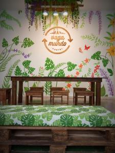 a room with a bed in front of a wall with plants at Hostel Vagamundo in Los Llanos de Aridane